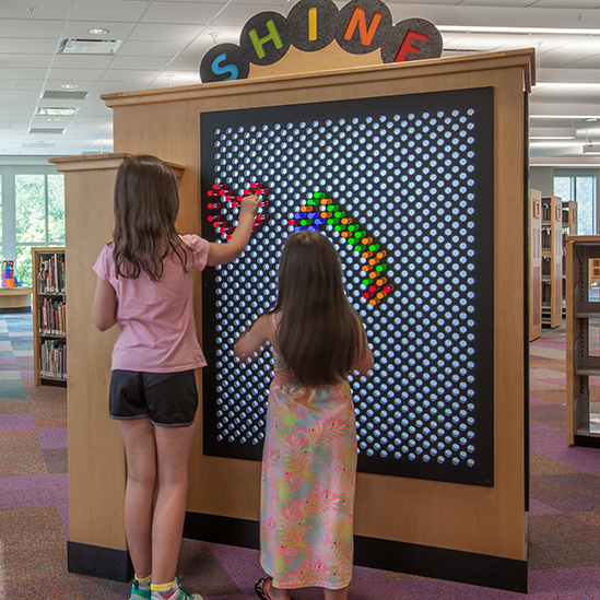 two girls playing with a light bright